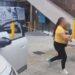 Fotografía de una mujer sosteniendo a un bebé entre brazos caminando hacia la puerta del hospital mientras a su lado hay un automovil estacionado con las puertas abiertas y una ambulancia a la esquina del edificio que se alcanza a notar como fondo